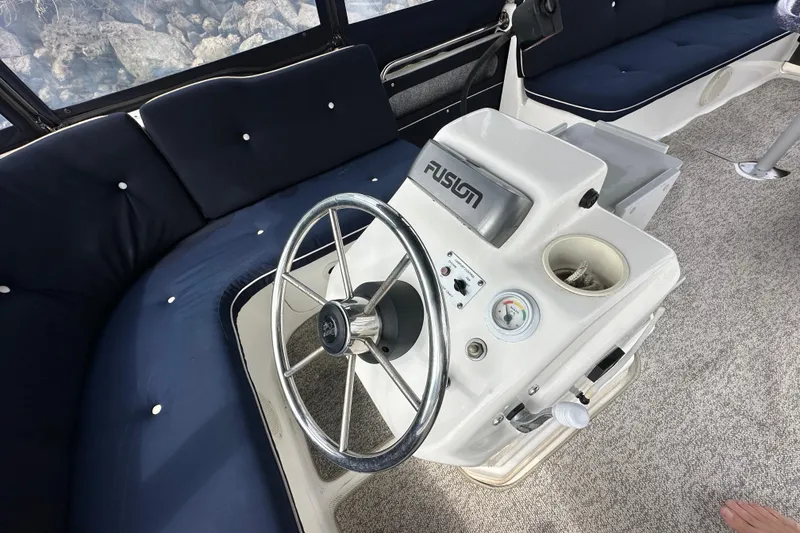 Slide: The Image of Steering console of a 2012 ElectraCraft CAT 16 boat with blue seating. - 6