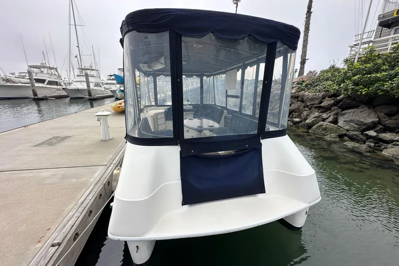 Slide: The Image of 2012 ElectraCraft CAT 16 boat docked at marina, featuring enclosed seating area. - 7