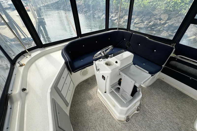 Slide: The Image of Interior of a 2012 ElectraCraft CAT 16 boat with seating and steering console. - 9