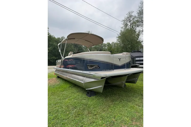 The Image of 2026 Tahoe Pontoon LTZ CRB boat on grass, featuring sleek design and canopy. - 1