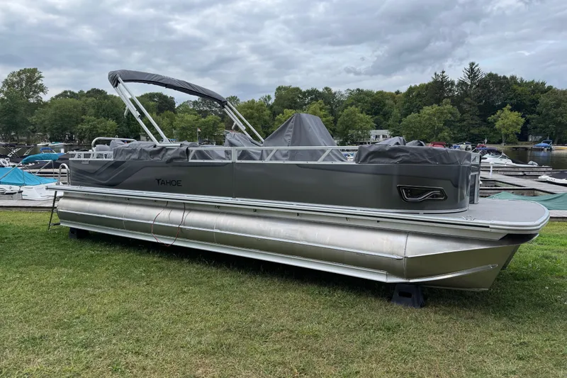 The Image of 2026 Tahoe Pontoon Sport 85 Center Console Fish 23 on grass near a marina. - 0