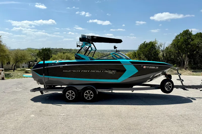 Slide: The Image of 2016 Nautique Super Air Nautique G23 boat on trailer, parked outdoors. - 16