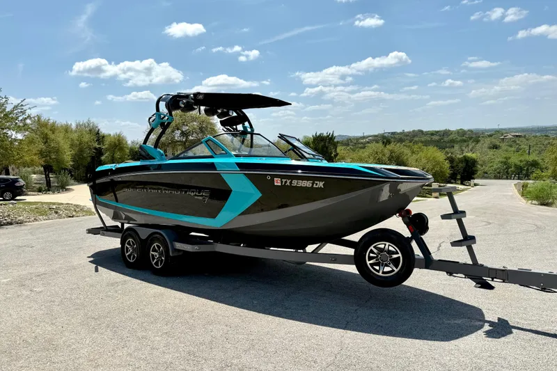 Slide: The Image of 2016 Nautique Super Air Nautique G23 boat on trailer under clear sky. - 17