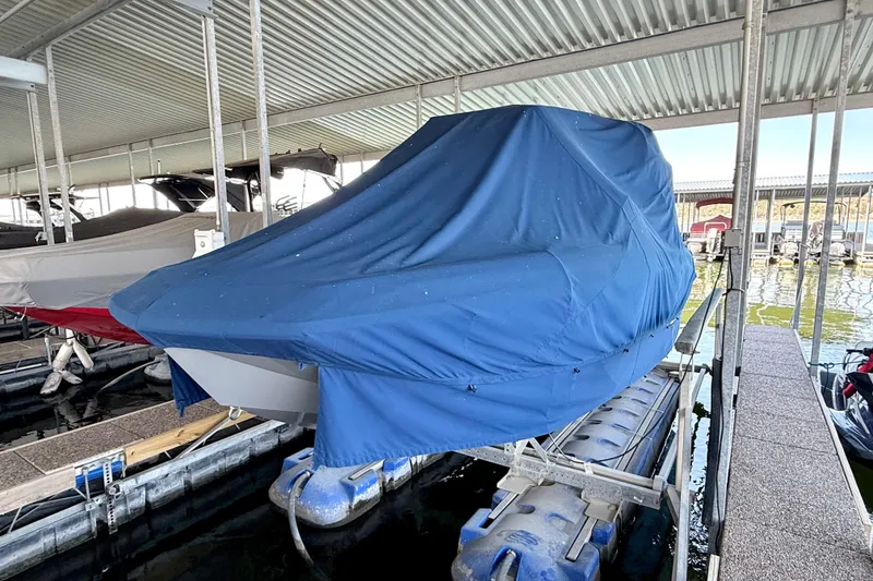 Slide: The Image of 2016 Nautique Super Air Nautique G23 covered in blue tarp at marina dock. - 18