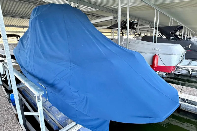 Slide: The Image of 2016 Nautique Super Air Nautique G23 covered in blue tarp at marina. - 19