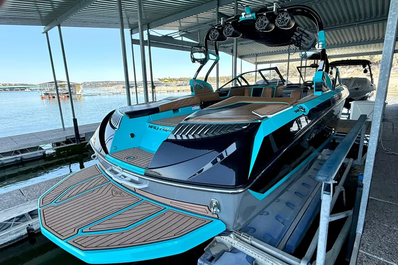 Slide: The Image of 2016 Nautique Super Air Nautique G23 boat docked, featuring sleek design and vibrant blue accents. - 22