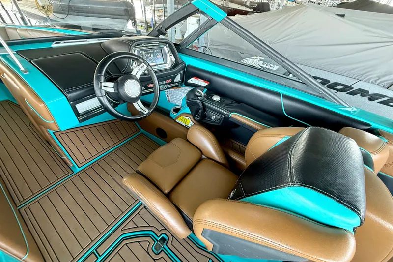 Slide: The Image of 2016 Nautique Super Air Nautique G23 interior with teal and brown accents, featuring a modern dashboard. - 29