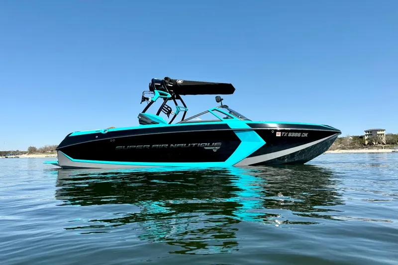 Slide: The Image of 2016 Nautique Super Air Nautique G23 boat on calm water, clear blue sky. - 3