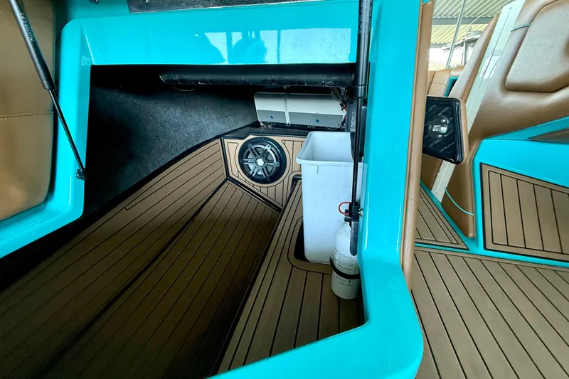 Slide: The Image of 2016 Nautique Super Air Nautique G23 interior with teal accents and wood-style flooring. - 32