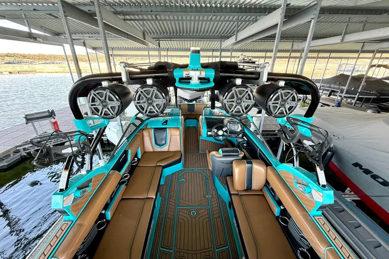 Slide: The Image of 2016 Nautique Super Air Nautique G23 boat interior with teal accents and advanced sound system. - 34