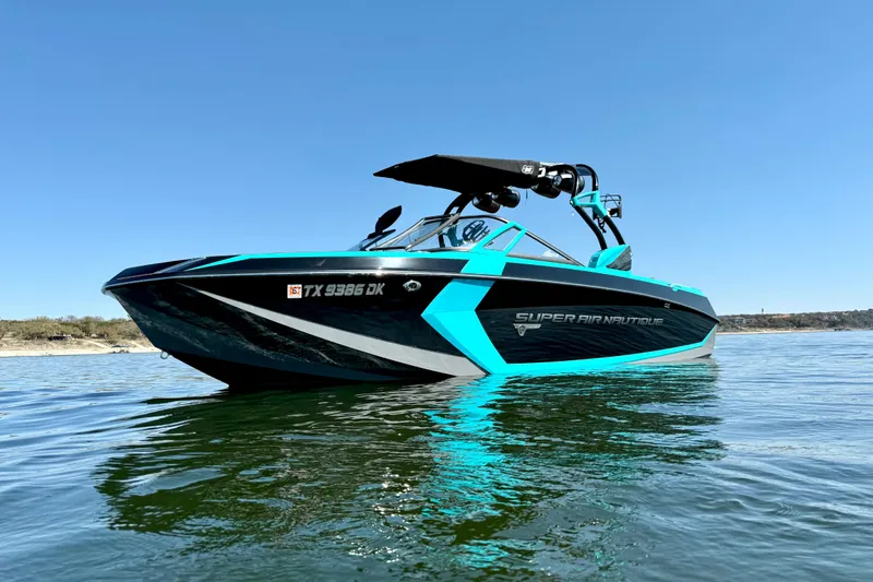 Slide: The Image of 2016 Nautique Super Air Nautique G23 boat on calm water under clear blue sky. - 8