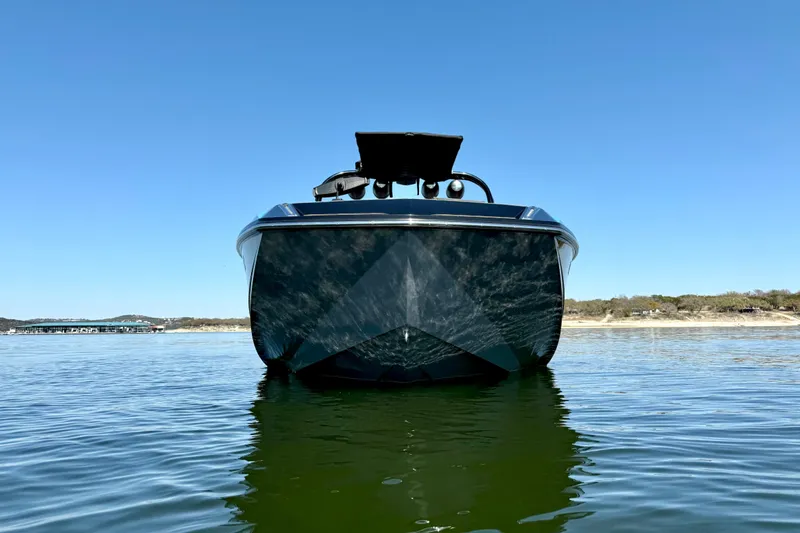 Slide: The Image of 2016 Nautique Super Air Nautique G23 boat on calm water under clear blue sky. - 9