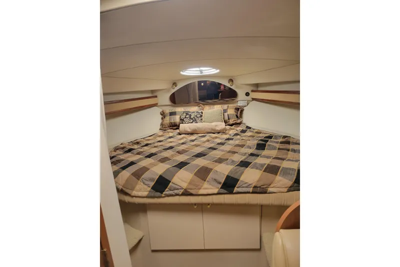Slide: The Image of Cozy cabin interior of 2000 Cruisers Yachts 3375 Express with plaid bedding. - 10