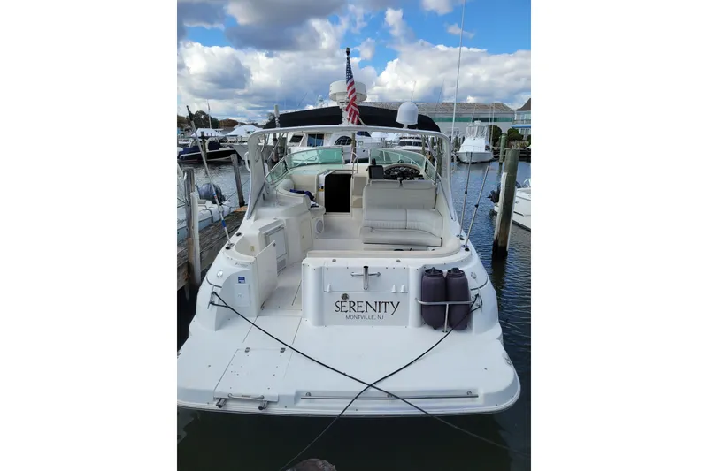 Slide: The Image of 2000 Cruisers Yachts 3375 Express docked, featuring spacious seating and "Serenity" nameplate. - 2