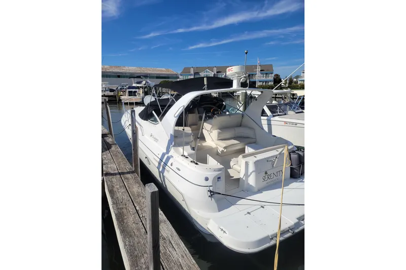 Slide: The Image of 2000 Cruisers Yachts 3375 Express docked at marina under clear blue sky. - 3