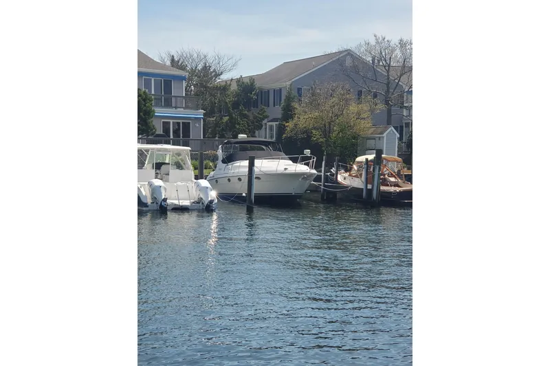 Slide: The Image of 2000 Cruisers Yachts 3375 Express docked near waterfront homes. - 4