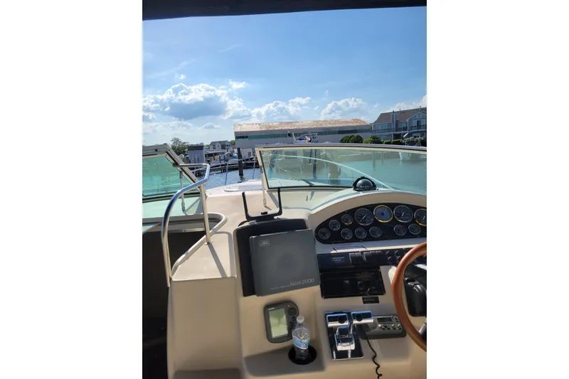 Slide: The Image of Cockpit view of 2000 Cruisers Yachts 3375 Express with clear skies and marina backdrop. - 5