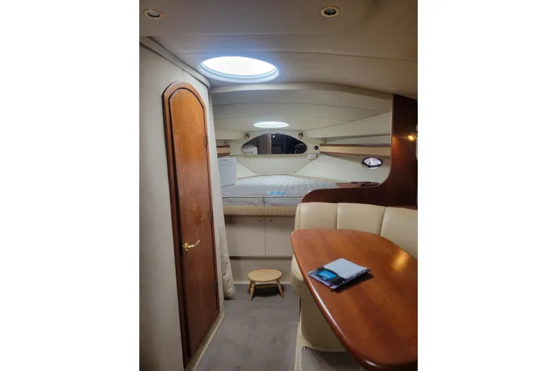 Slide: The Image of Interior of 2000 Cruisers Yachts 3375 Express, featuring a cozy cabin and dining area. - 6