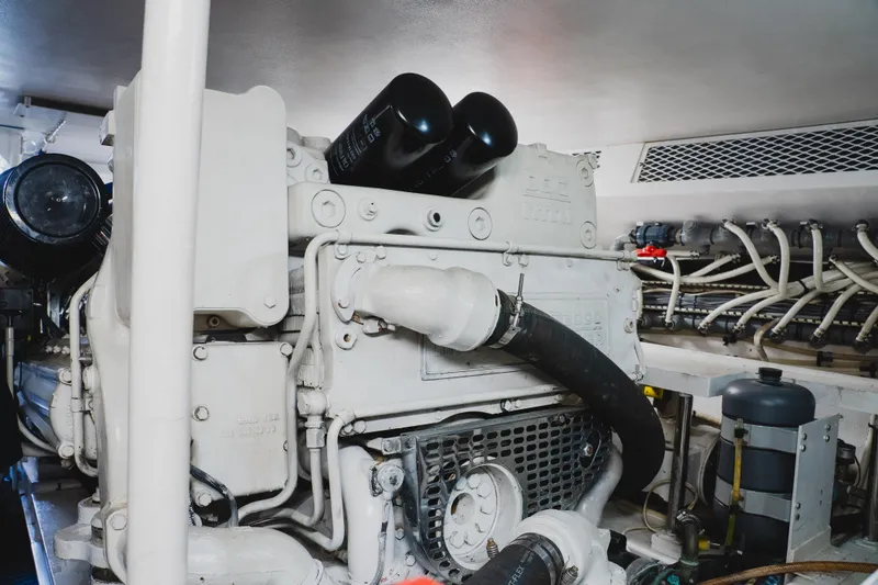 Slide: The Image of Engine room of a 1999 Viking 58 Convertible yacht, showcasing machinery and piping. - 103