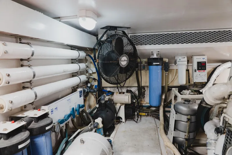 Slide: The Image of Engine room of a 1999 Viking 58 Convertible yacht, featuring filtration systems and machinery. - 106
