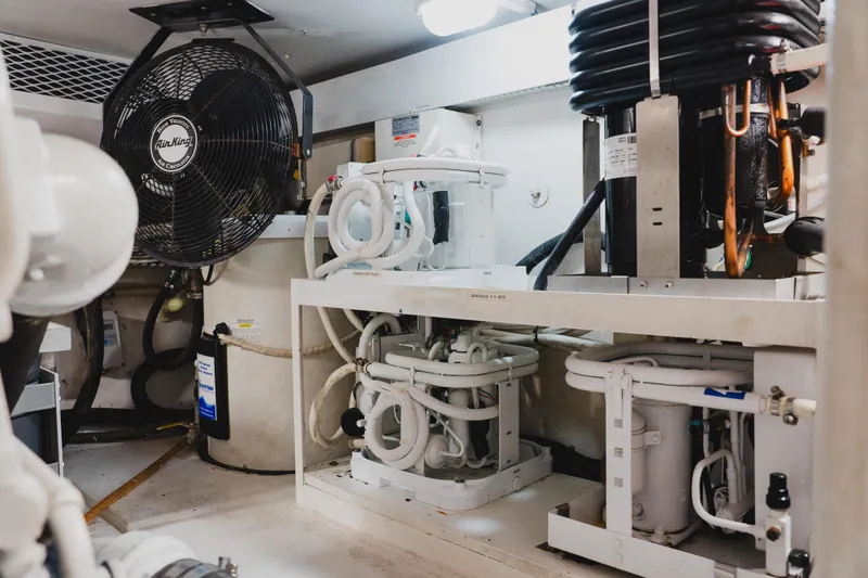 Slide: The Image of Engine room of a 1999 Viking 58 Convertible yacht, featuring mechanical equipment and ventilation. - 108