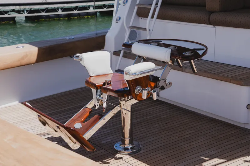 Slide: The Image of Fishing chair on 1999 Viking 58 Convertible yacht deck, featuring polished wood and metal accents. - 13