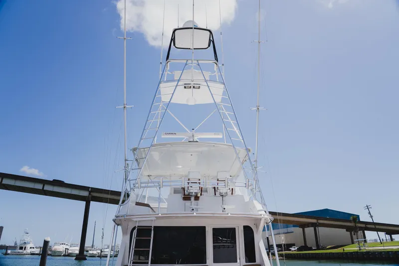 Slide: The Image of 1999 Viking 58 Convertible yacht with tower, docked under clear blue sky. - 16