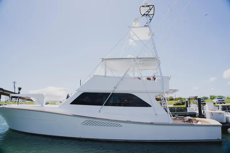 Slide: The Image of 1999 Viking 58 Convertible yacht docked at marina under clear blue sky. - 2
