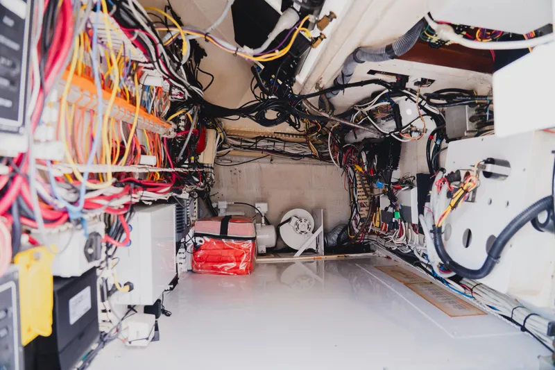 Slide: The Image of Engine room of a 1999 Viking 58 Convertible yacht, showcasing complex wiring and equipment. - 33