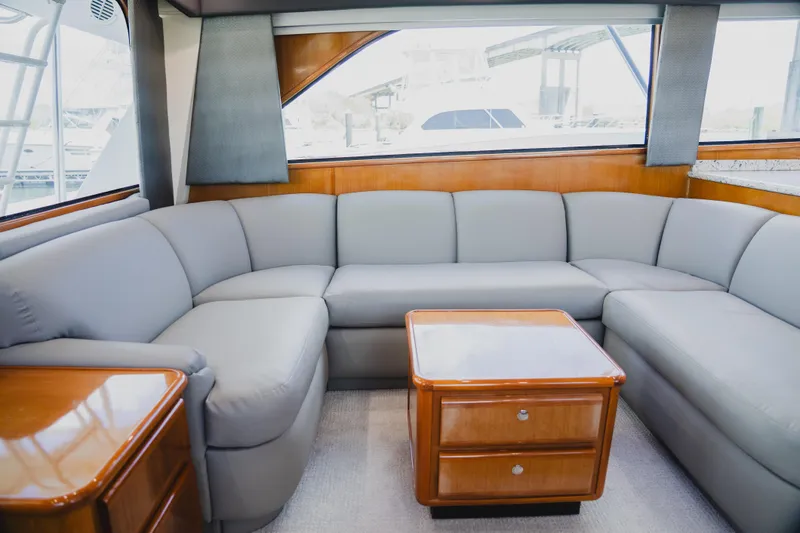 Slide: The Image of Luxurious interior of a 1999 Viking 58 Convertible yacht with plush seating and wooden accents. - 36