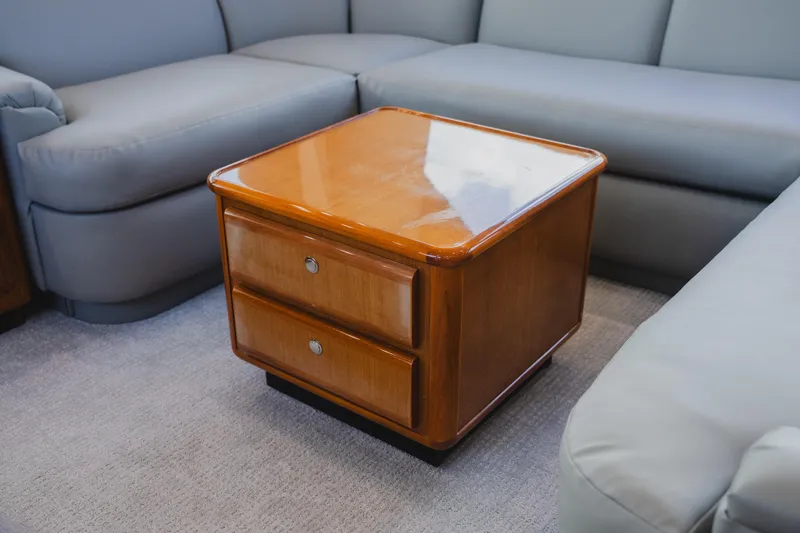 Slide: The Image of Wooden table with drawers on a Viking 58 Convertible yacht, 1999 model, surrounded by gray seating. - 38