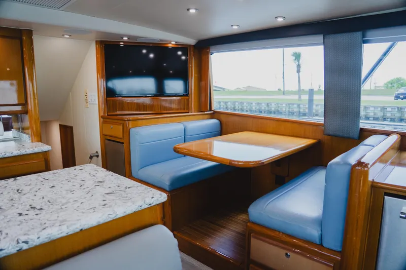 Slide: The Image of Interior of 1999 Viking 58 Convertible yacht with blue seating and wooden table. - 40
