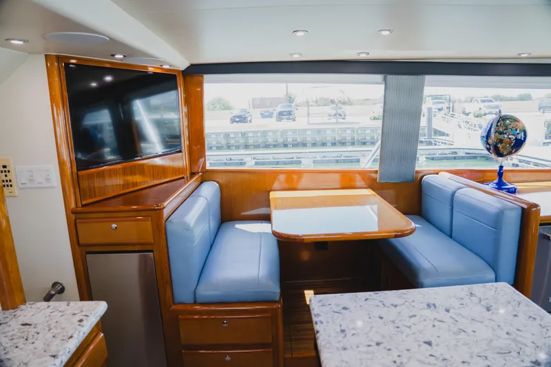 Slide: The Image of Interior of 1999 Viking 58 Convertible yacht with dining area, TV, and window view. - 43