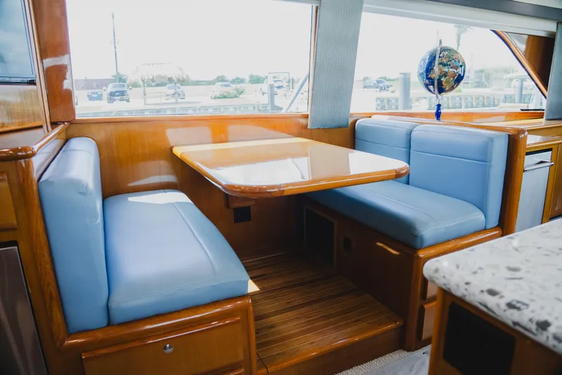 Slide: The Image of Interior of 1999 Viking 58 Convertible yacht with blue seating and wooden table. - 44