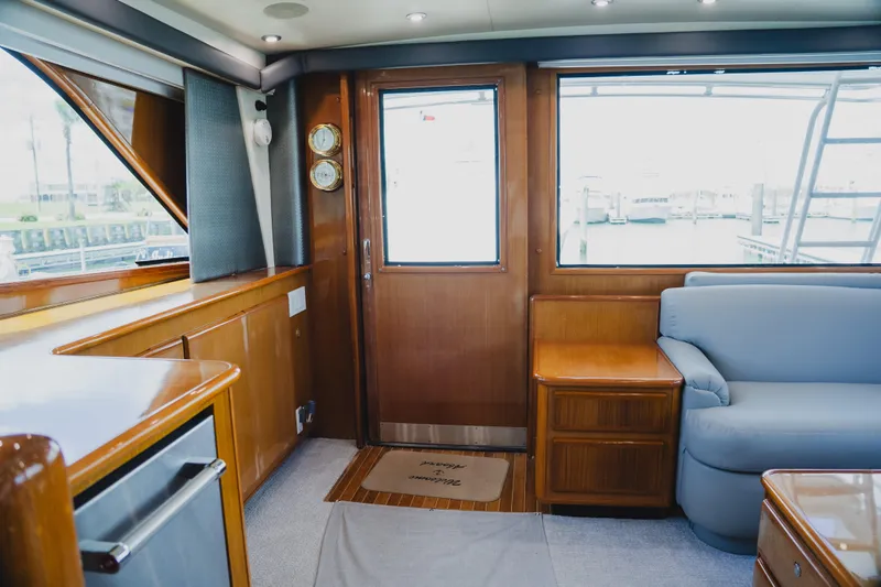 Slide: The Image of Interior of a 1999 Viking 58 Convertible yacht with wooden cabinetry and blue seating. - 45