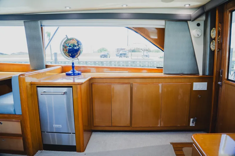 Slide: The Image of Interior of 1999 Viking 58 Convertible yacht with wooden cabinetry and a globe. - 46
