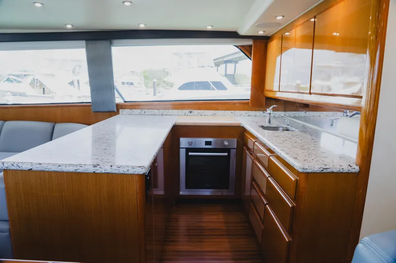 Slide: The Image of Luxurious kitchen interior of 1999 Viking 58 Convertible yacht with modern appliances and wood cabinetry. - 49