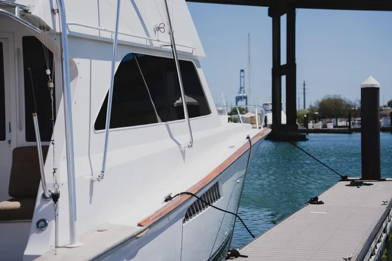 Slide: The Image of 1999 Viking 58 Convertible yacht docked at marina under clear blue sky. - 5