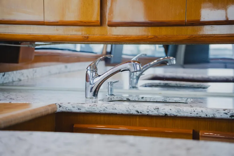 Slide: The Image of Luxury kitchen interior of 1999 Viking 58 Convertible yacht with sleek faucet and marble countertop. - 52