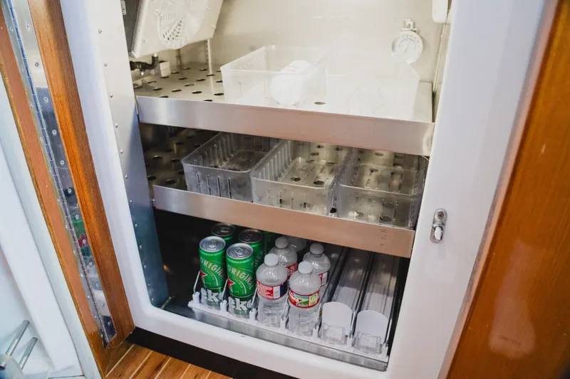 Slide: The Image of Refrigerator inside 1999 Viking 58 Convertible yacht, stocked with drinks and water bottles. - 56