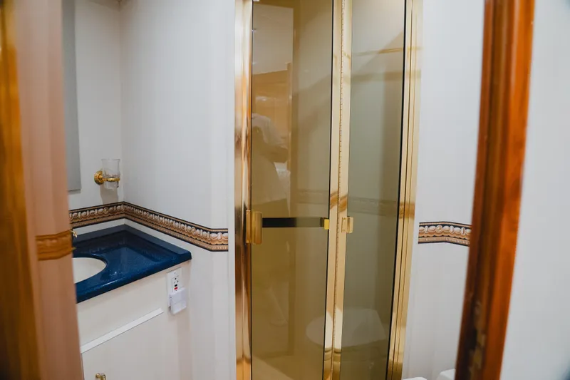 Slide: The Image of Luxurious bathroom interior of 1999 Viking 58 Convertible yacht with gold accents. - 64