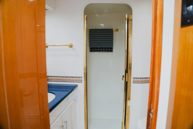 Slide: The Image of Bathroom interior of 1999 Viking 58 Convertible yacht with elegant fixtures and blue countertop. - 74