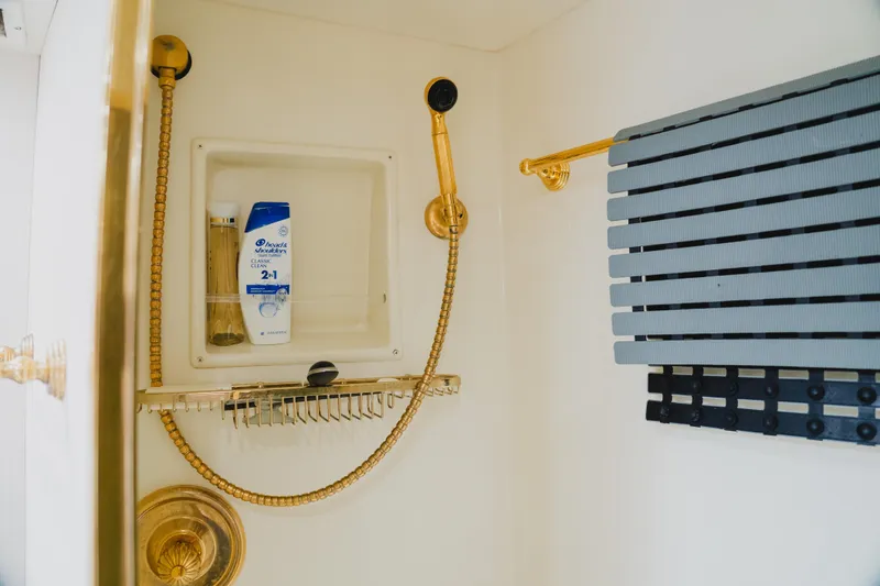 Slide: The Image of Shower area in 1999 Viking 58 Convertible yacht with gold fixtures and toiletries. - 75
