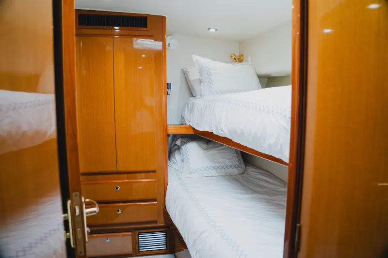 Slide: The Image of Interior of 1999 Viking 58 Convertible yacht with wooden cabinetry and bunk beds. - 79