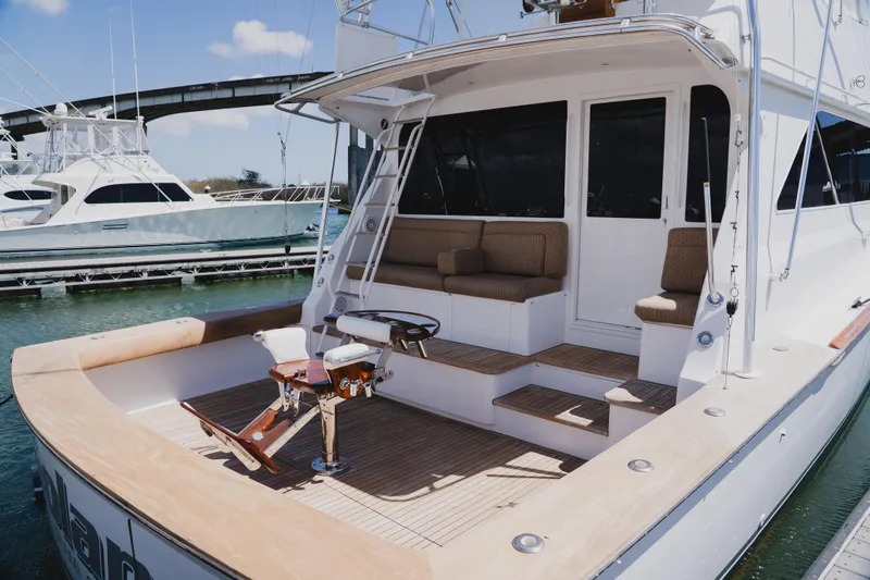 Slide: The Image of 1999 Viking 58 Convertible yacht with spacious deck and seating area, docked at marina. - 8