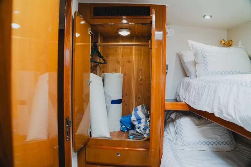 Slide: The Image of Interior of 1999 Viking 58 Convertible yacht with wooden closet and bunk beds. - 80