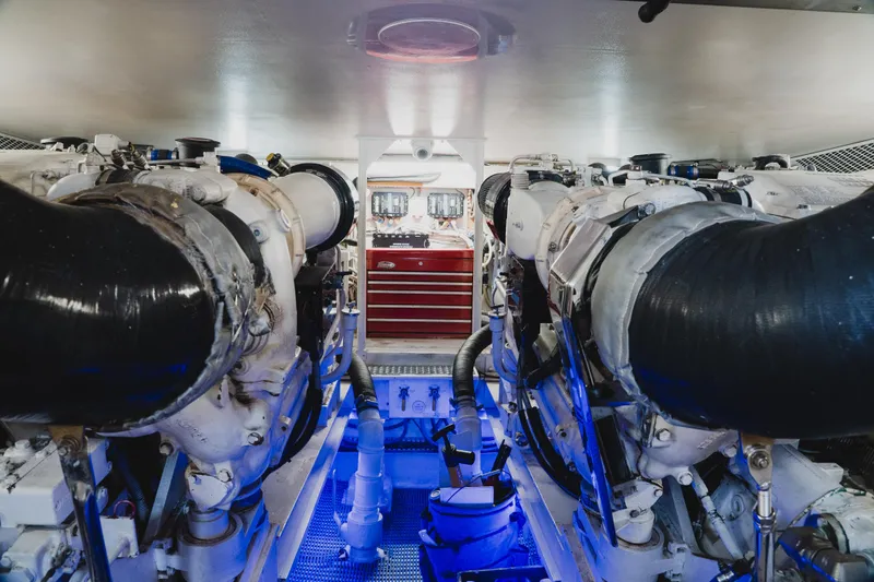 Slide: The Image of Engine room of a 1999 Viking 58 Convertible yacht, featuring dual engines and a red toolbox. - 90