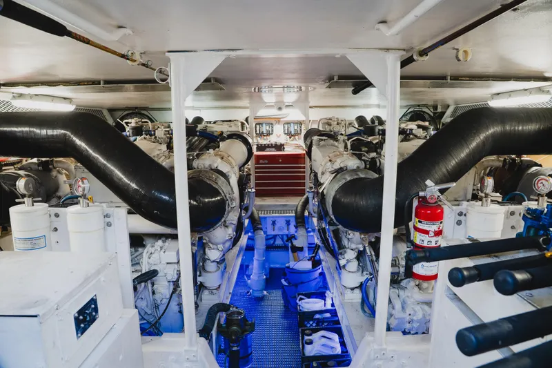 Slide: The Image of Engine room of a 1999 Viking 58 Convertible yacht, featuring dual engines and safety equipment. - 91