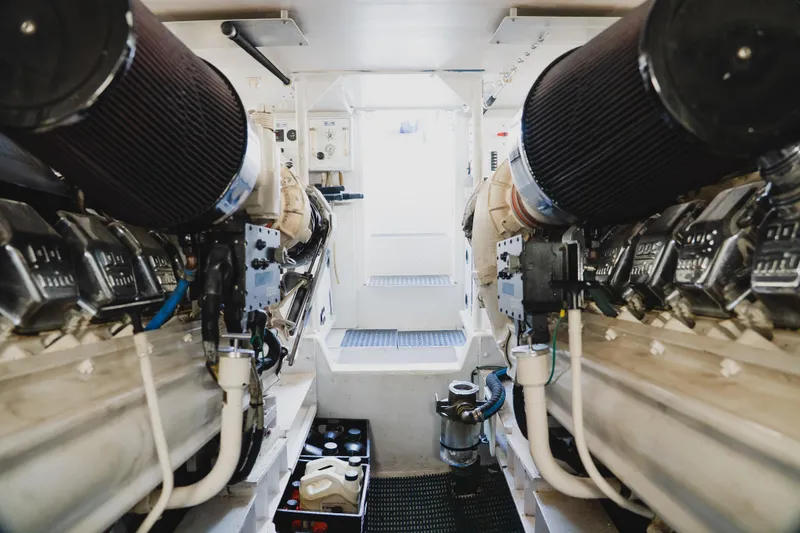 Slide: The Image of Engine room of a 1999 Viking 58 Convertible yacht, showcasing dual engines and mechanical components. - 92