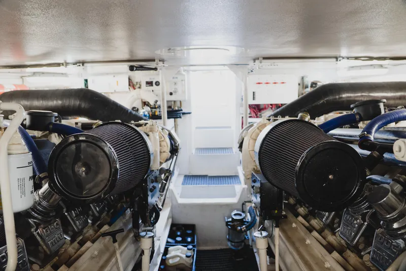 Slide: The Image of Engine room of a 1999 Viking 58 Convertible yacht, showcasing dual engines and mechanical components. - 93